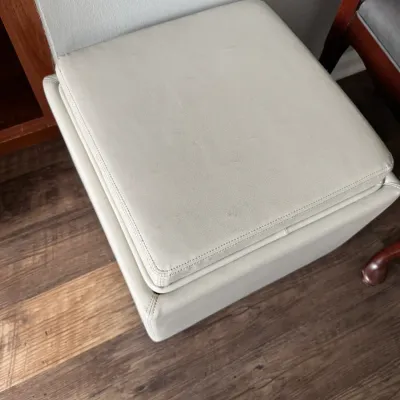 Sale Photo Thumbnail #290: Contemporary square storage ottoman upholstered in off-white faux leather with a removable padded lid.