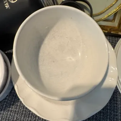 Sale Photo Thumbnail #299: White ceramic gravy boat or sauce server with an attached underplate, showing some interior crazing and wear from use.