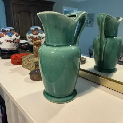 Sale Photo Thumbnail #257: Vintage green ceramic pitcher with a crackle glaze finish, displayed on a mantel alongside other decorative Asian-style jars and boxes.