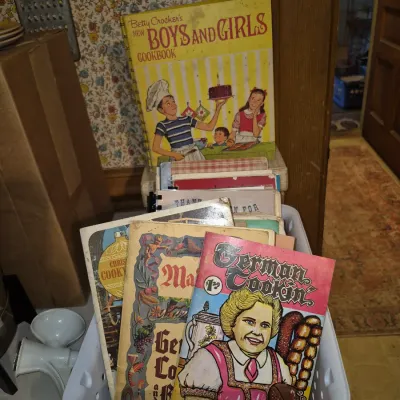 Sale Photo Thumbnail #15: Collection of vintage cookbooks including Betty Crocker's New Boys and Girls Cookbook and a German Cookin' booklet stored in a plastic bin.
