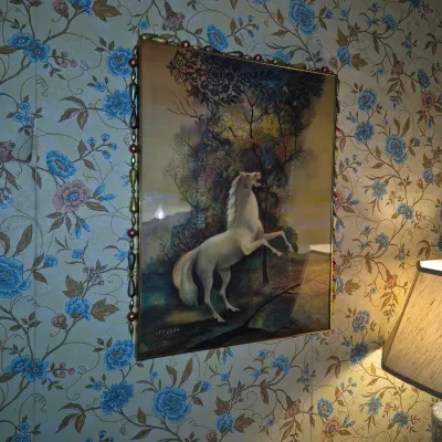 Sale Photo Thumbnail #76: Framed vintage art print depicting a rearing white horse or unicorn, numbered 155/250 in the lower left corner and trimmed with decorative beaded garland.