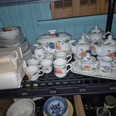 Sale Photo Thumbnail #262: Collection of floral ceramic dinnerware and tea sets, including tea pots, teacups, a covered casserole dish, and stacked plates.