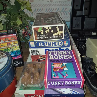 Sale Photo Thumbnail #17: Collection of vintage board games and puzzles, including Scrabble Sentence Cube Game, Rack-O, Funny Bones, and Monopoly.