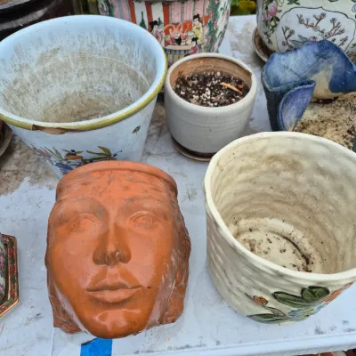 Sale Photo Thumbnail #20: Collection of assorted ceramic and terracotta planters, featuring a terracotta head planter and Chinese porcelain pot covers.