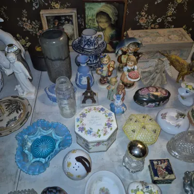 Sale Photo Thumbnail #8: Collection of vintage decor and collectibles, including Hummel figurines, blue opalescent carnival glass, trinket boxes, pottery, and framed artwork.