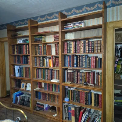 Sale Photo Thumbnail #102: Large wooden multi-section bookcase filled with various vintage and contemporary hardcover books.