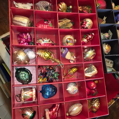 Sale Photo Thumbnail #85: Collection of vintage glass and figural Christmas ornaments, neatly organized in a red compartmentalized storage tray.