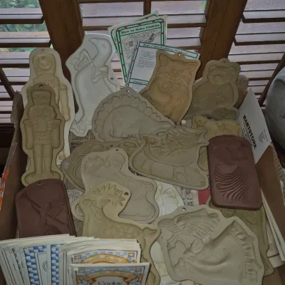 Sale Photo Thumbnail #41: Collection of vintage stoneware and terra cotta cookie molds in various shapes, accompanied by recipe booklets.