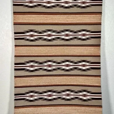 Sale Photo Thumbnail #11: Handwoven Navajo-style wool rug or wall hanging, featuring geometric diamond patterns in natural tones of brown, tan, cream, and grey.