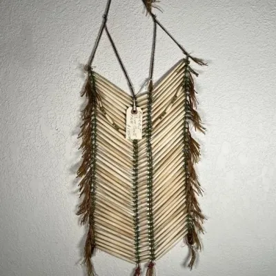 Sale Photo Thumbnail #15: Native American style bone breastplate wall hanging, featuring long bone beads, green spacer beads, and leather fringe.