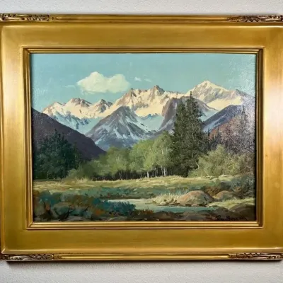 Sale Photo Thumbnail #2: Vintage oil on canvas landscape painting depicting a snow-capped mountain range, signed by the artist and housed in a wide, ornate gold-finished frame.