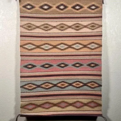 Sale Photo Thumbnail #10: Handwoven Southwestern-style wool textile featuring horizontal bands of geometric diamond patterns in earth tones, pink, and blue.