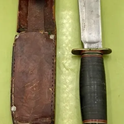Sale Photo Thumbnail #19: Vintage Marbles Gladstone hunting knife with a stacked leather handle and its original worn leather sheath.