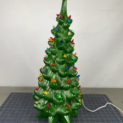 Vintage green ceramic Christmas tree with multi-colored plastic bulbs and a red star topper, shown illuminated.