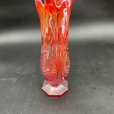 Vintage red carnival glass vase featuring a ruffled, flame-like rim and an intricate pressed diamond pattern on a hexagonal base.