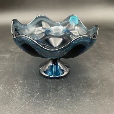 Mid-century modern blue glass pedestal bowl featuring a ruffled rim and a glossy finish.