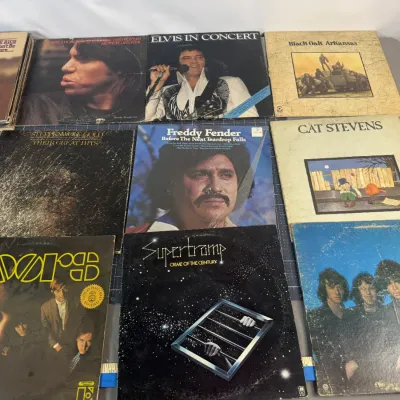 Collection of vintage vinyl LP records featuring artists such as The Doors, Supertramp, Cat Stevens, Elvis Presley, and Freddy Fender,...