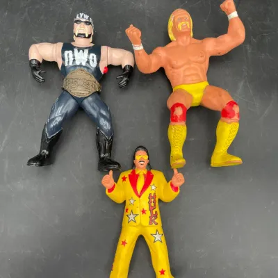Vintage wrestling action figures featuring Hulk Hogan in classic yellow trunks, Hollywood Hogan in nWo gear, and Jimmy Hart in a yellow...