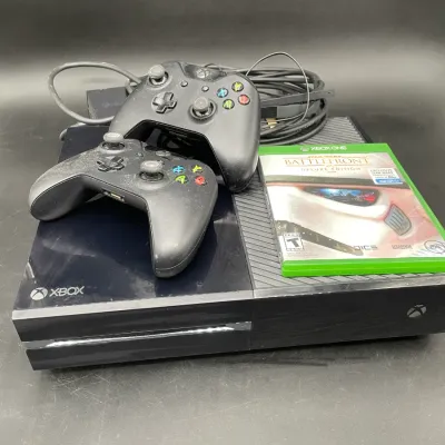 Original Xbox One console bundle, including two wireless controllers, power and HDMI cables, and a copy of Star Wars Battlefront Deluxe...