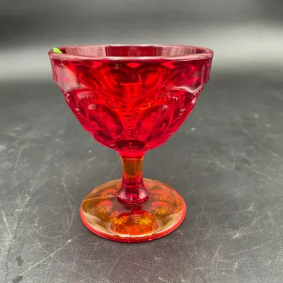 Vintage L.E. Smith amberina glass goblet in the Moon and Stars pattern, featuring a vibrant red bowl transitioning to an amber-orange base.