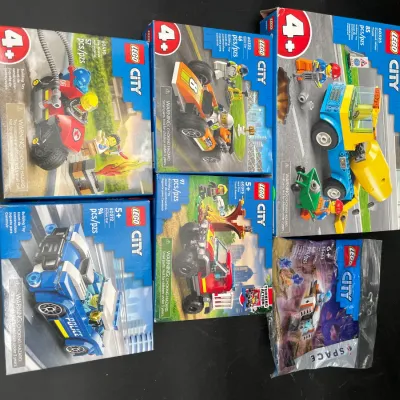 Collection of five Lego City building sets in original boxes, including Police Car and Cement Mixer, alongside one Space-themed polybag set.