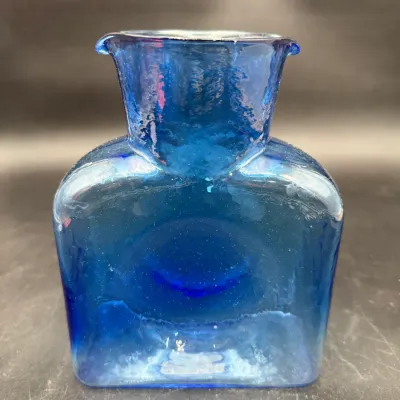 Blenko cobalt blue glass water bottle, featuring a classic double-spouted design and textured finish.
