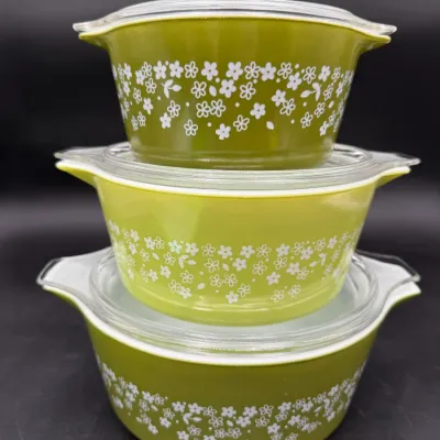 Vintage Pyrex Spring Blossom Green Cinderella casserole dishes with clear glass lids, stacked in a set of three.