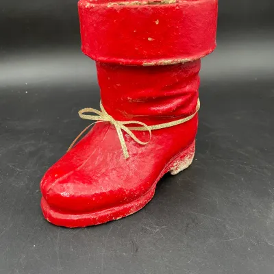 Vintage papier-mâché Santa boot candy container, featuring a red textured finish and a gold ribbon bow.