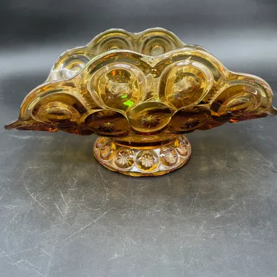 Vintage amber glass banana boat bowl in the Moon and Stars pattern, featuring a scalloped rim and a pedestal base.