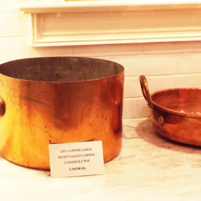 Pair of antique heavy-gauge copper cookware pieces, including a large straight-sided casserole pot with long iron handle and a shallow...