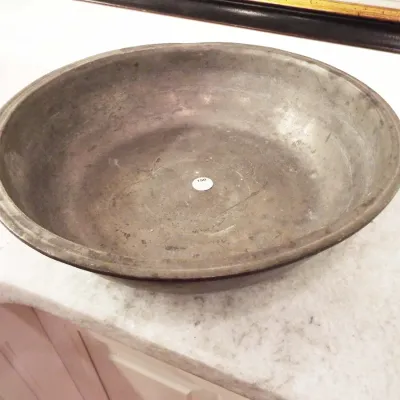 Antique metal pewter-style basin or shallow bowl featuring an aged patina and rolled rim.