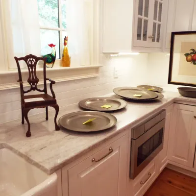 Kitchen counter display featuring a miniature Chippendale-style salesman sample chair, pewter chargers and plates, decorative glass...