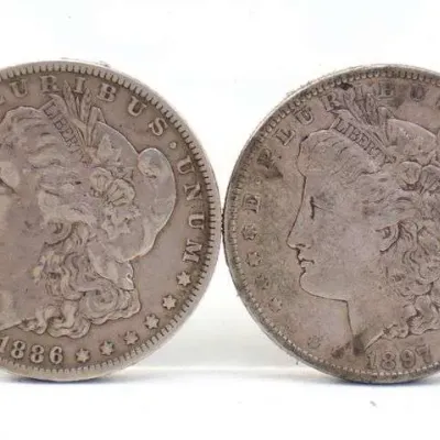Two United States Morgan silver dollars, dated 1886 and 1897, showing circulated wear and natural patina.