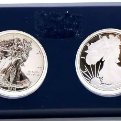 Two-coin 2012 American Eagle silver dollar set, featuring a reverse proof and a proof coin housed in a blue display stand.