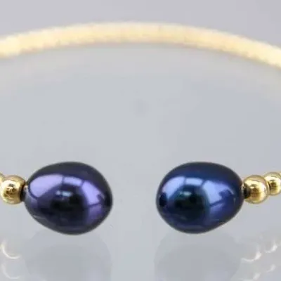 Gold-tone beaded bypass bangle bracelet featuring two dark purple-blue cultured pearls at the open ends.