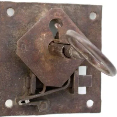 Antique wrought iron rim lock with skeleton key, showing heavy surface rust and patina.