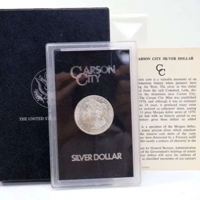 GSA Carson City Morgan silver dollar in its original plastic holder, accompanied by the black presentation box and informational card.