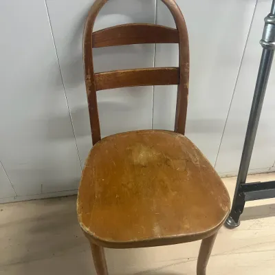 Sale Photo Thumbnail #38: Vintage bentwood dining chair with a curved backrest and ladder-back slats, showing significant wear and patina to the finish.