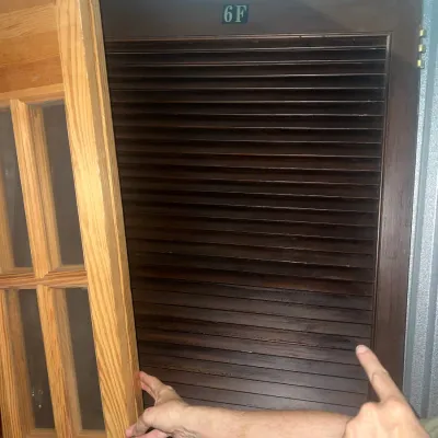 Sale Photo Thumbnail #54: Dark wood louvered door featuring the number "6F" at the top, shown alongside a natural wood French door with glass panes.