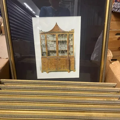 Sale Photo Thumbnail #15: Framed architectural illustration of a Chippendale-style cabinet, housed in a beaded gold-finished frame with a dark mat, shown with several matching frames.