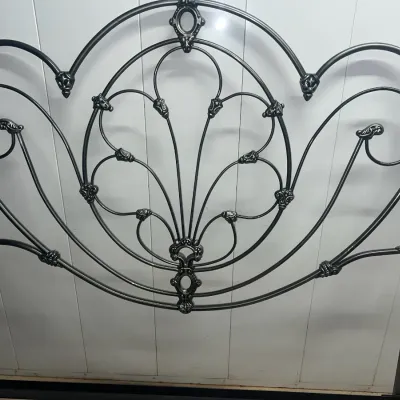 Sale Photo Thumbnail #41: Ornate black metal headboard featuring intricate scrollwork, floral accents, and brass finials in an Art Nouveau style.