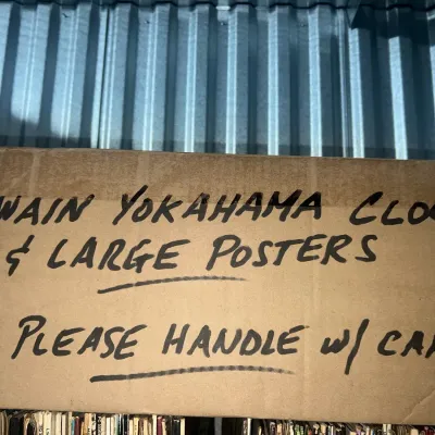 Sale Photo Thumbnail #20: A cardboard storage box labeled in black marker with "Hawain Yokohama Clock & Large Posters" and "Please Handle w/ Care."
