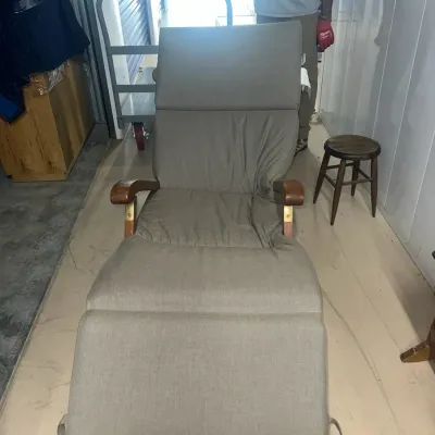 Sale Photo Thumbnail #66: Adjustable wooden chaise lounge chair with light brown fabric cushions, featuring curved wooden armrests and brass hardware.