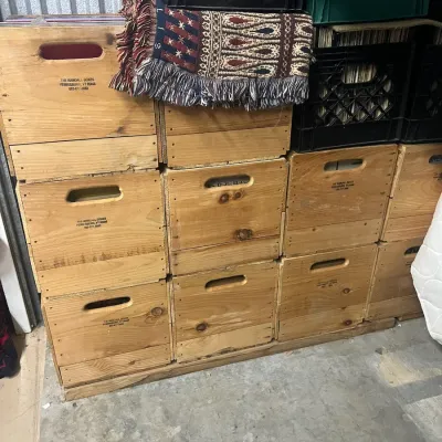 Sale Photo Thumbnail #9: Stack of vintage wooden Randall Boxes from Ferrisburg, Vermont, alongside plastic milk crates, used for vinyl record storage.
