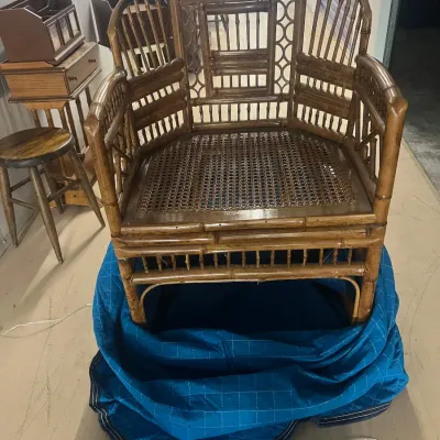Sale Photo Thumbnail #43: Vintage faux bamboo barrel chair featuring a woven cane seat and intricate spindle backrest, resting on a blue moving blanket.