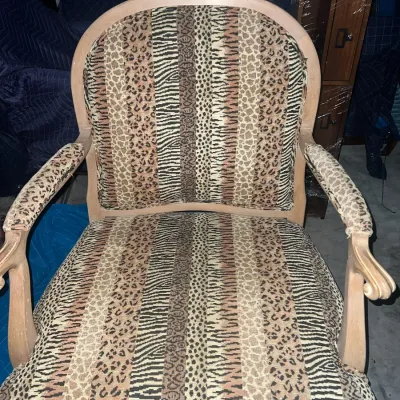 Sale Photo Thumbnail #80: Vintage French provincial style armchair featuring a light wood frame and upholstered in a multi-patterned animal print fabric with zebra and leopard stripes.