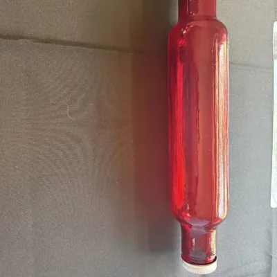 Vintage ruby red glass rolling pin with a metal screw-on cap, designed to be filled with cold water for pastry making.