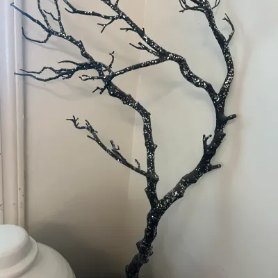 Decorative black branch display piece adorned with silver glitter, mounted on a matching square base.