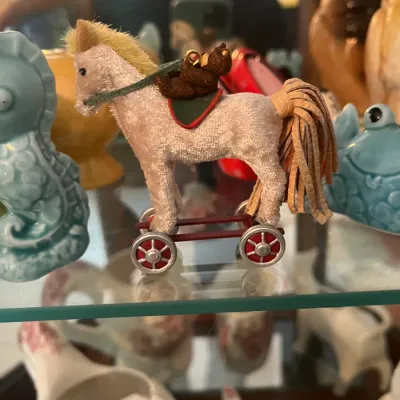 Miniature flocked horse on wheeled platform w small rider