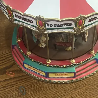 Vintage "The Red Ruby Carousel" miniature musical carousel, featuring a red and white striped canopy and detailed carousel horses.